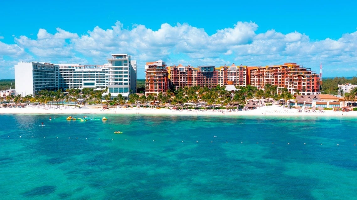 a large swimming pool surrounded by palm trees and buildings