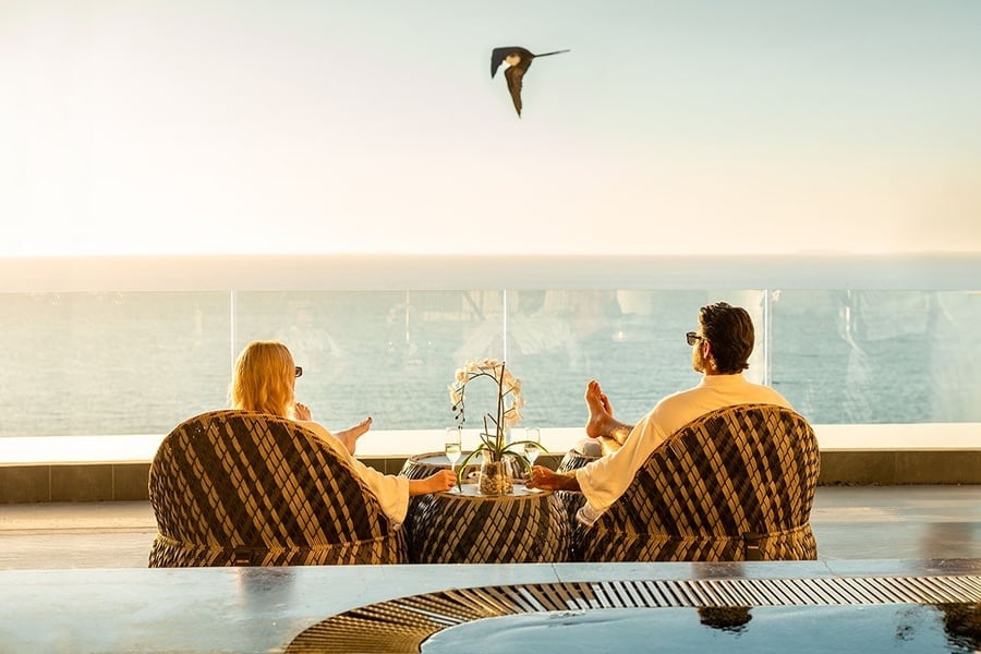 a man and a woman are sitting at a table with food and drinks