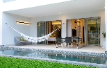 a white house with a swimming pool and a hammock
