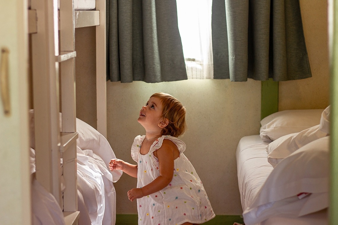 una niña con un vestido de lunares está mirando hacia arriba en una habitación