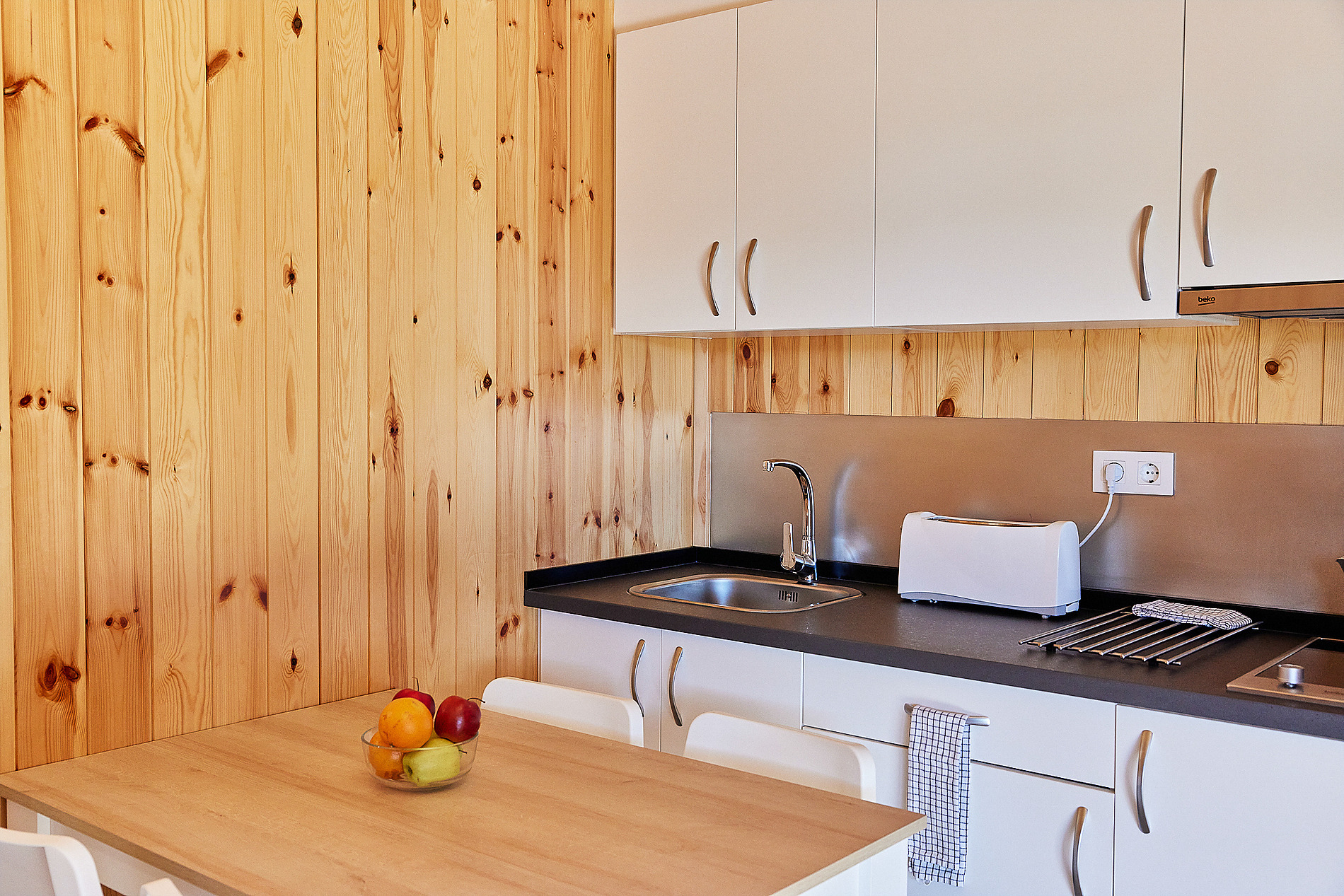 Cocina rústica de madera con encimera oscura y electrodomésticos modernos ideal para Taiga: Puerto Santa Maria.