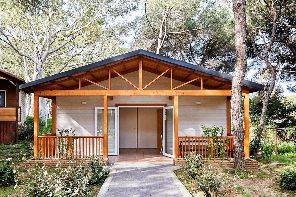 une petite maison blanche avec un porche en bois