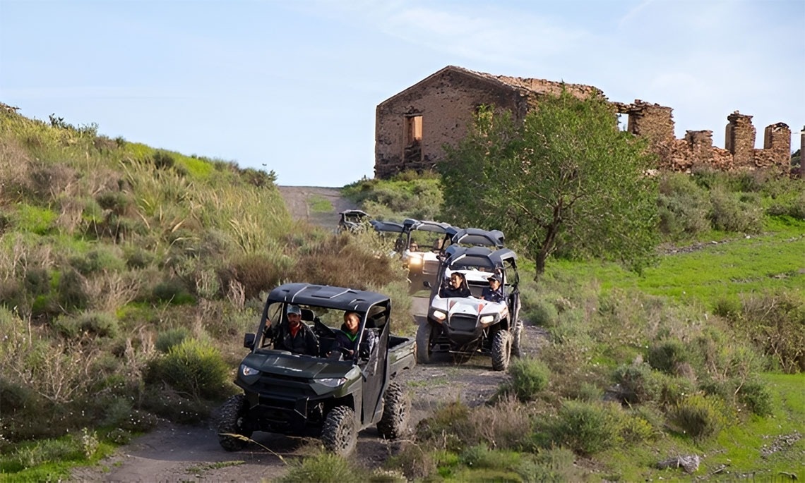 a row of atvs are driving down a dirt road