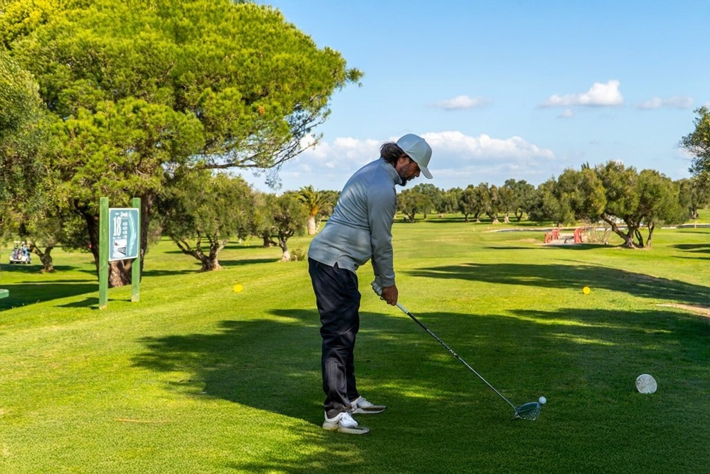 un drapeau vert est suspendu à un poteau sur un terrain de golf