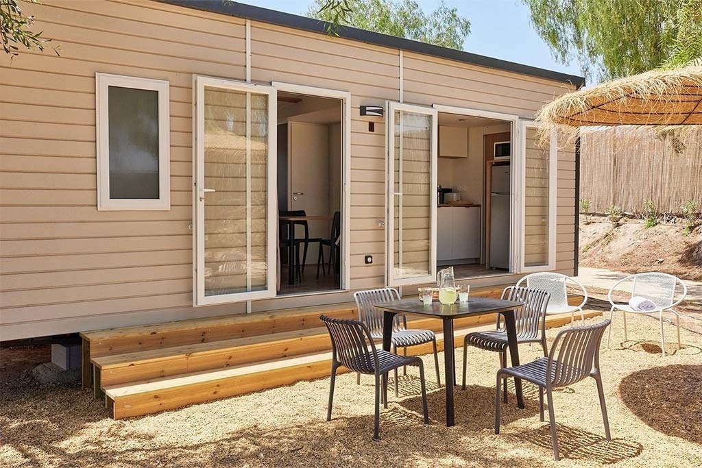une maison mobile avec une table et des chaises à l' extérieur