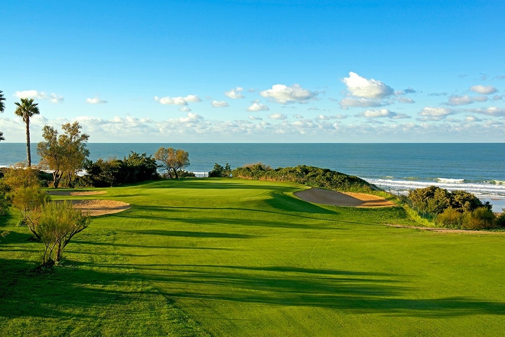 un drapeau vert est suspendu à un poteau sur un terrain de golf