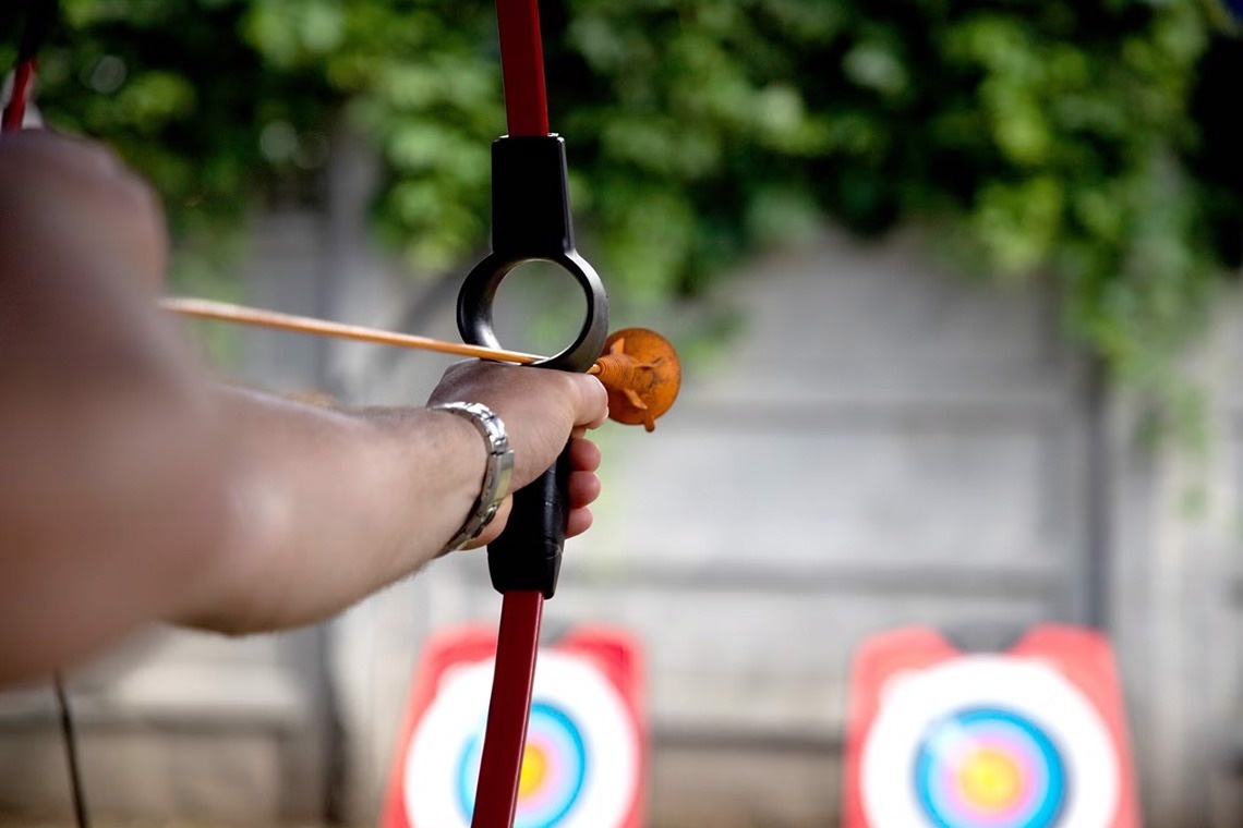 una persona dispara un arc a un objectiu