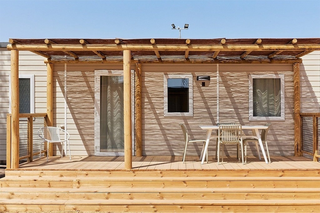 une maison mobile avec une table et des chaises sur le porche