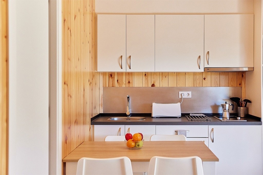 une cuisine avec des armoires blanches et un réfrigérateur blanc