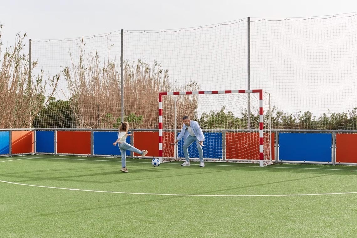 un home i una menina jugant a un partit de futbol