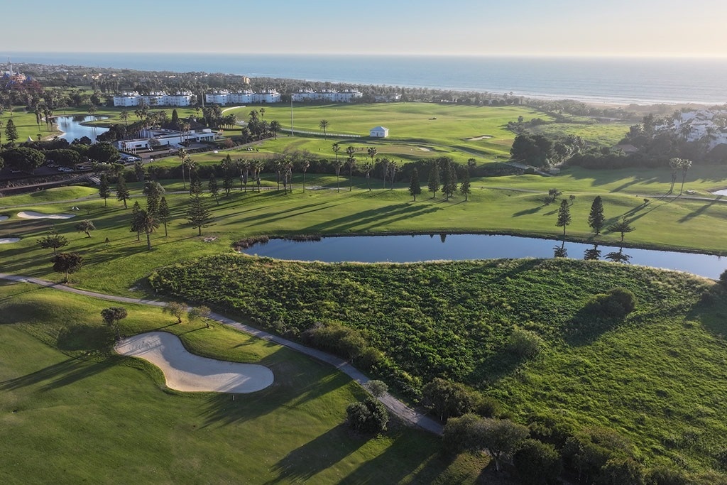 un drapeau vert est suspendu à un poteau sur un terrain de golf