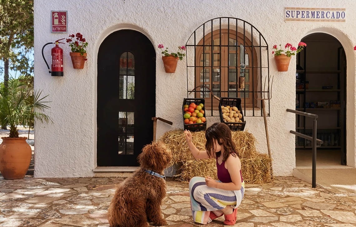 una menina acaricia un perro en un supermercado