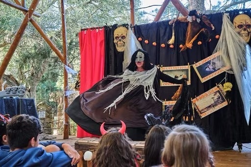 una bruixa està fent un acte en un escenari decorat per halloween .