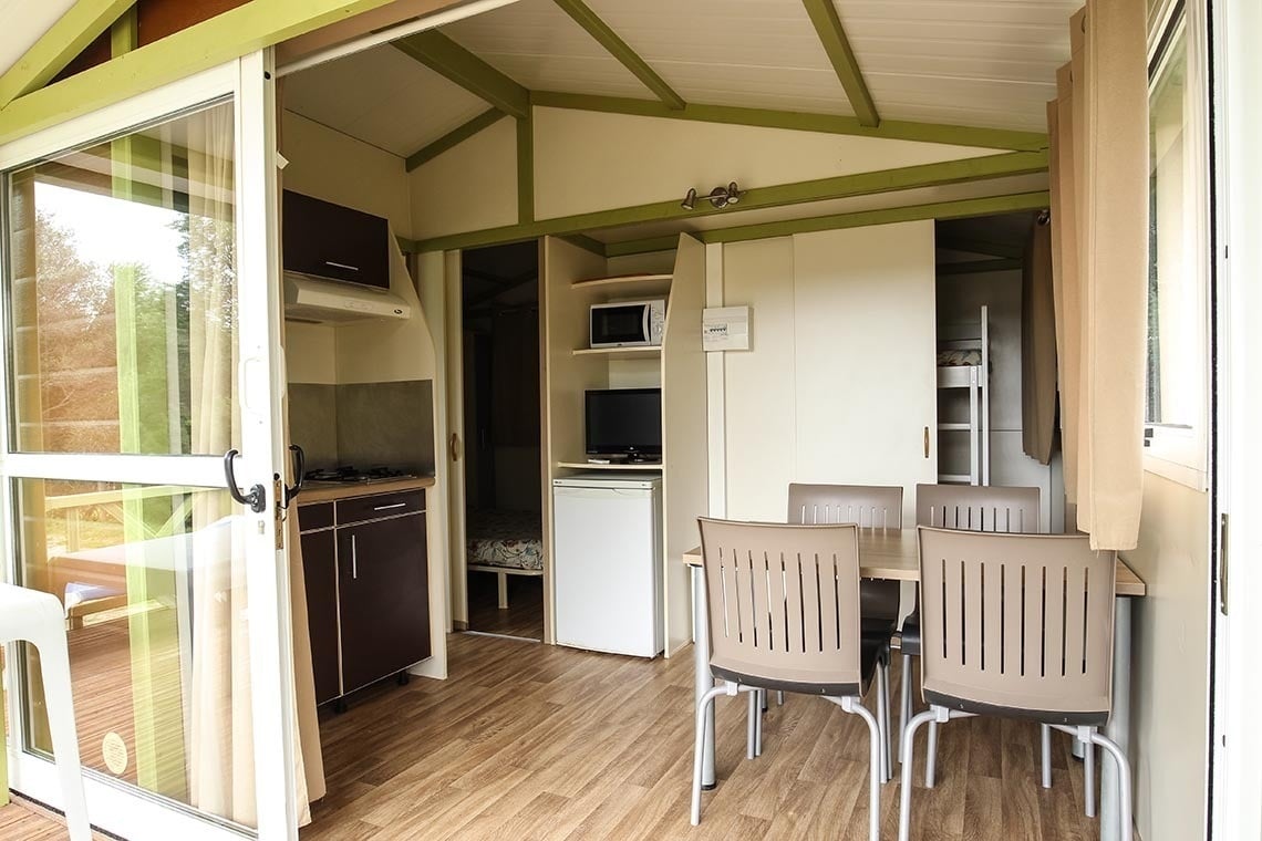 the inside of a cabin with a table and chairs