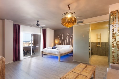 una habitación con una cama y un ventilador de techo