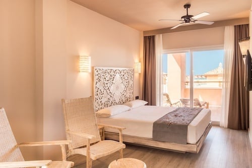 una habitación con una cama y un ventilador de techo