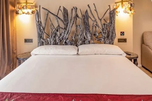 una cama con una cabecera hecha de ramas de madera