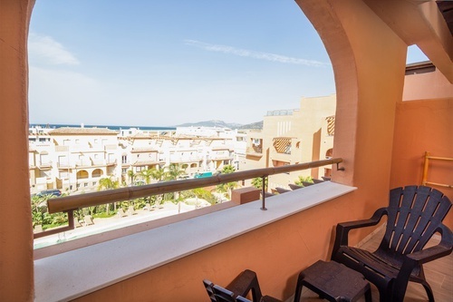 un balcón con dos sillas y una mesa con vista al océano