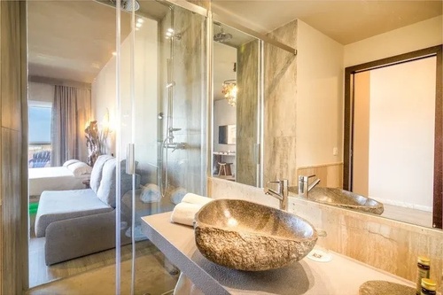 un baño con un lavabo de piedra y un espejo