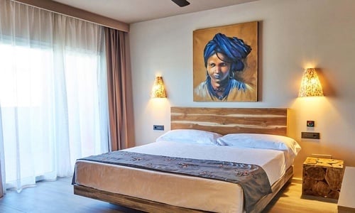 un dormitorio con una cama y una pintura en la pared