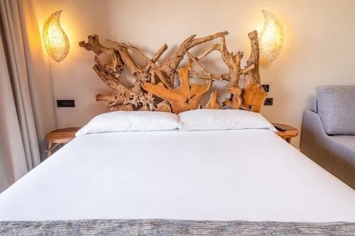 una cama con una cabecera de madera y almohadas blancas