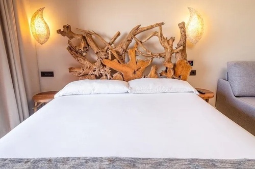 a bed with a wooden headboard and white sheets