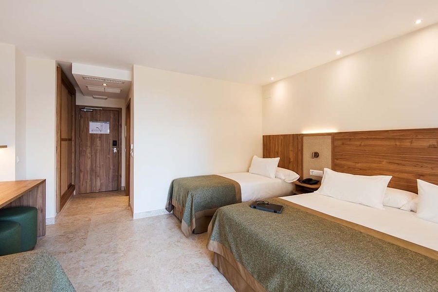 una habitación de hotel con dos camas y una puerta de madera