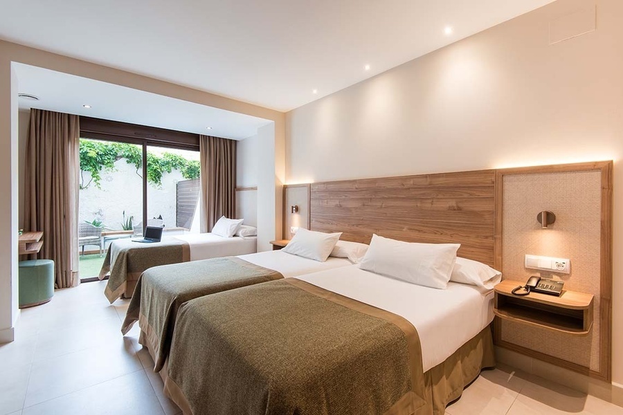 una habitación de hotel con dos camas y una ventana