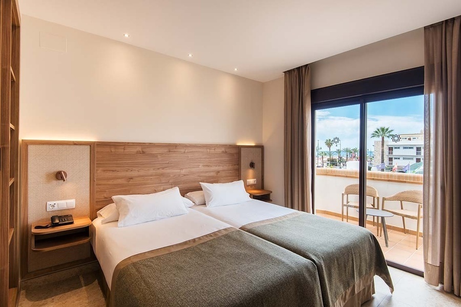 una habitación de hotel con dos camas y una ventana