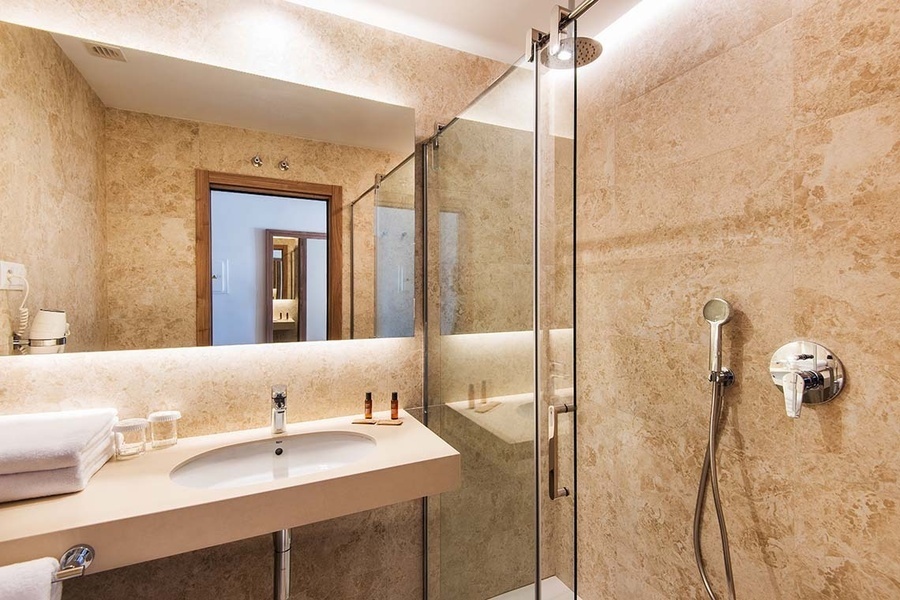 un baño con un lavabo y una ducha de vidrio