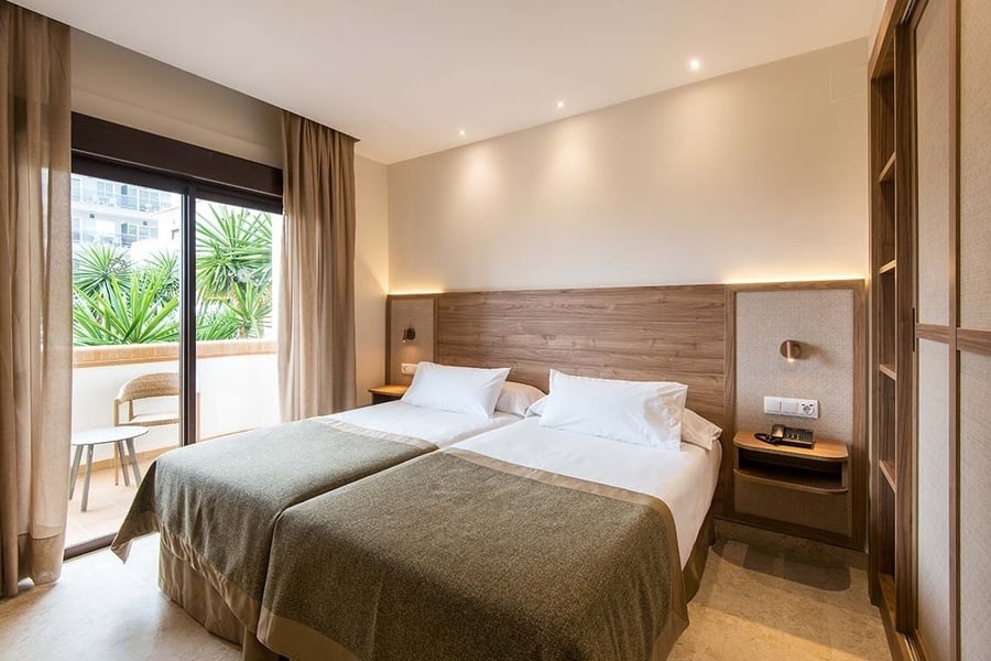 una habitación de hotel con dos camas y una ventana