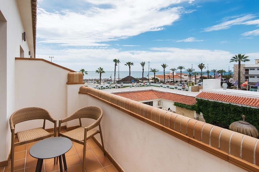un balcón con dos sillas y una mesa con vistas al océano