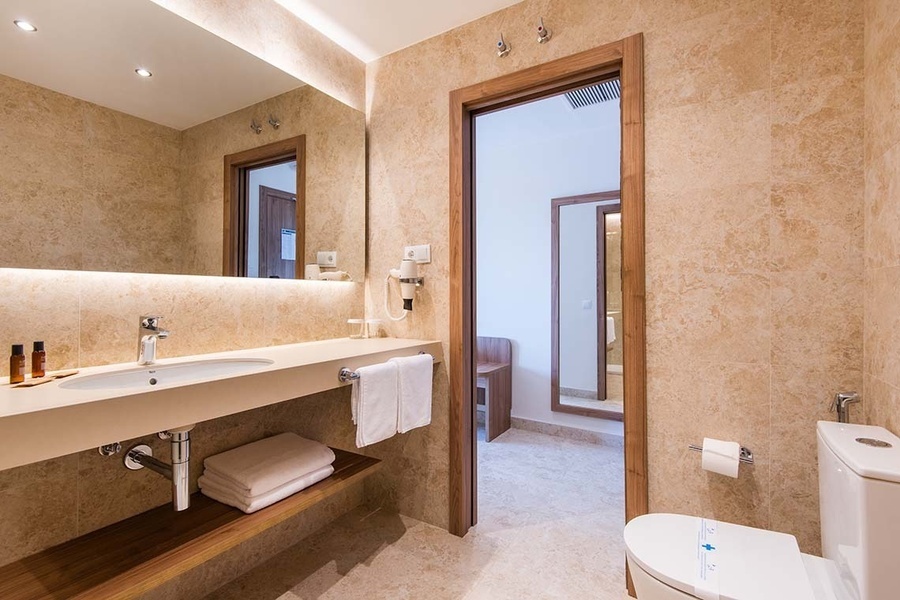 un baño con lavabo , inodoro y espejo