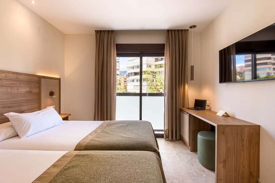 una habitación de hotel con dos camas y una televisión