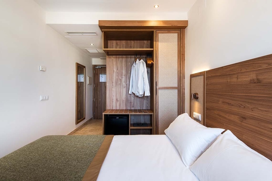 una habitación de hotel con una cama y un armario de madera