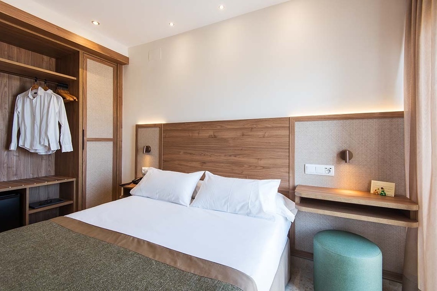 una habitación de hotel con una cama y un escritorio