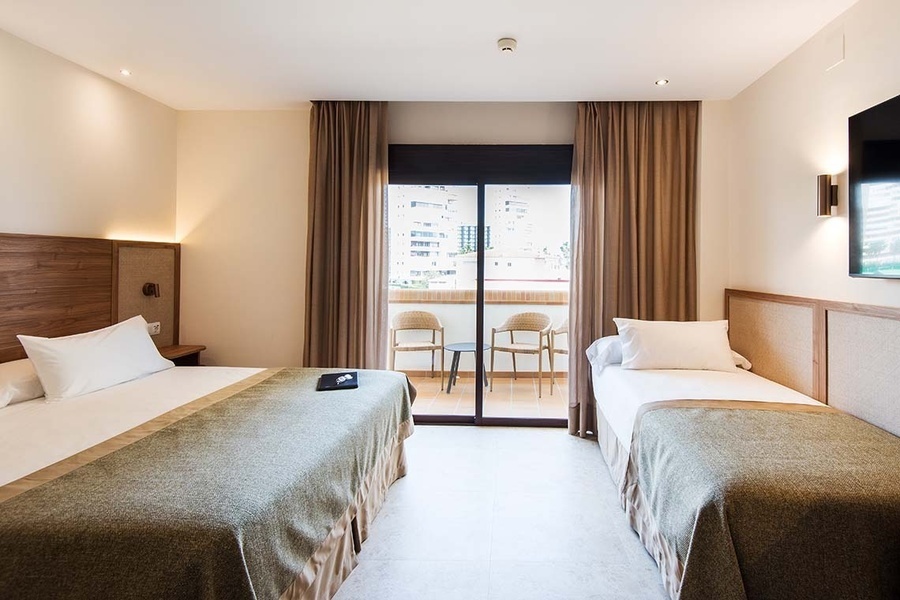 una habitación de hotel con dos camas y una televisión