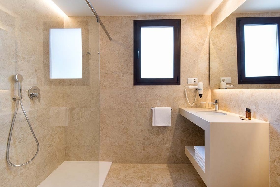 un baño con dos ventanas y un lavabo