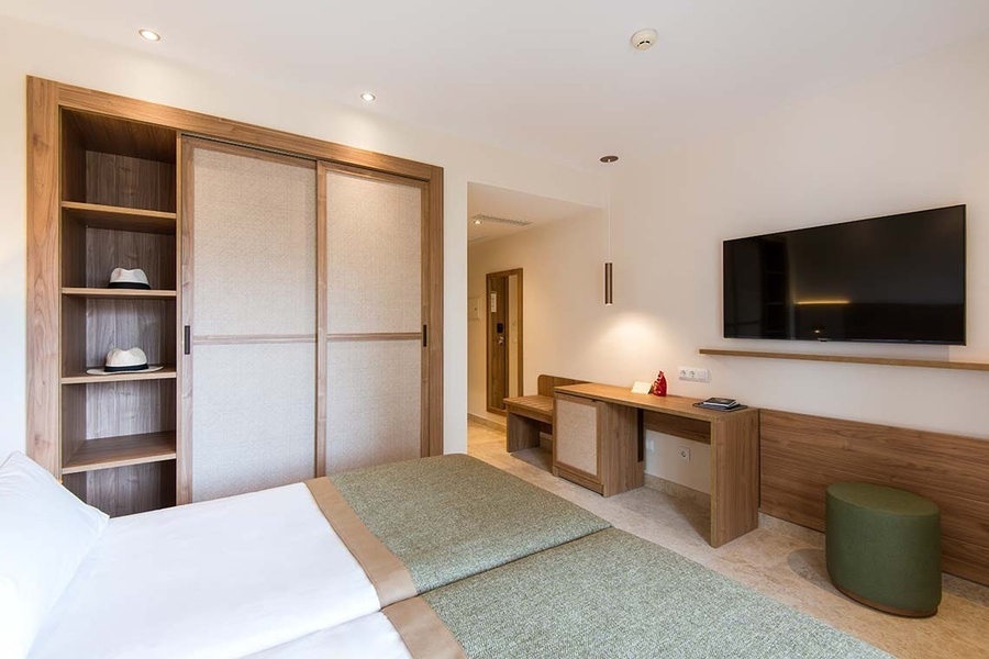 una habitación con dos camas y una televisión de pantalla plana