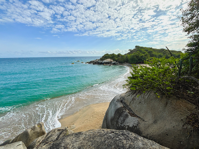 Playa caribeña rodeada de rocas y vegetación exuberante, perfecta para tu Tequendama: Corporativa.