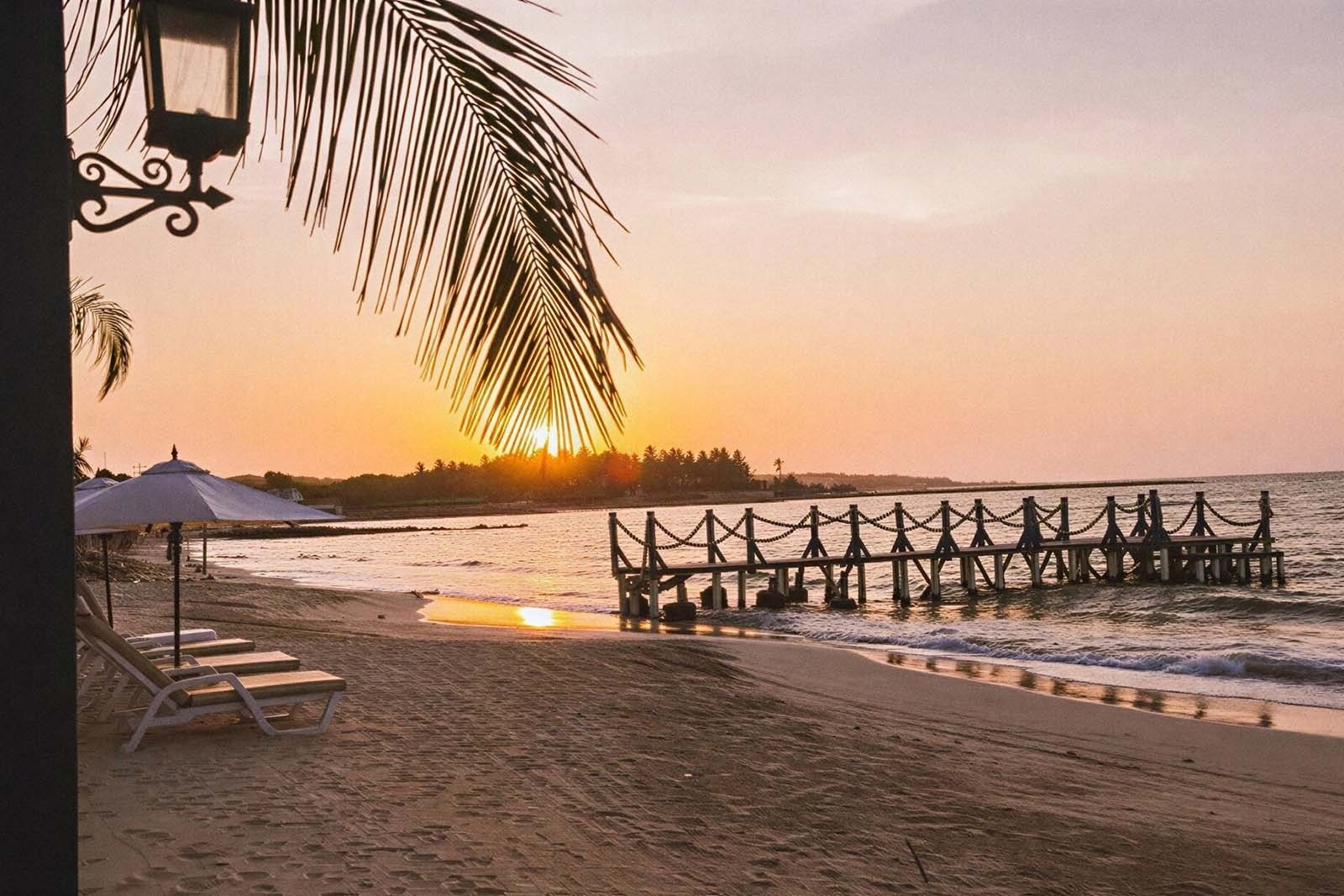 Sunset over the pier at Marine Beach Club & Hotel, Cartagena. Beachfront relaxation.