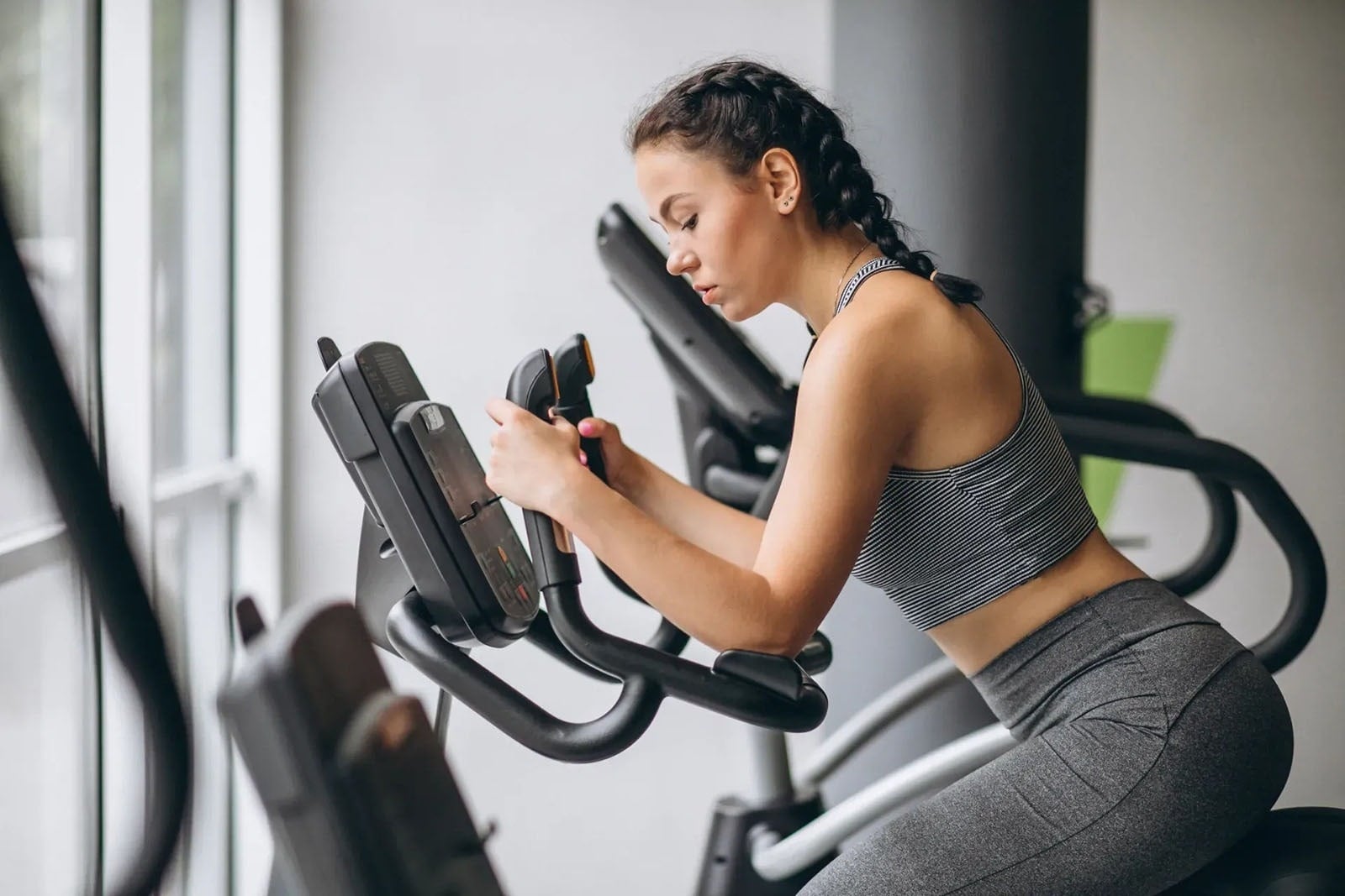 Tequendama: Corporativa. Woman on stationary bike in gym.