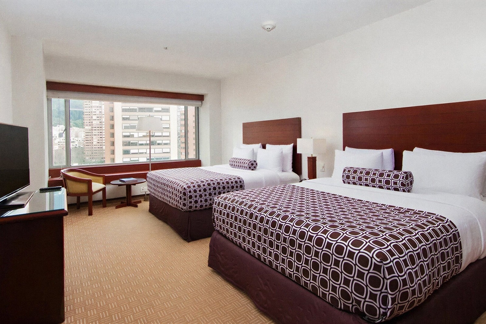 Two queen beds with brown and white patterned comforters at Tequendama Suites Bogotá.