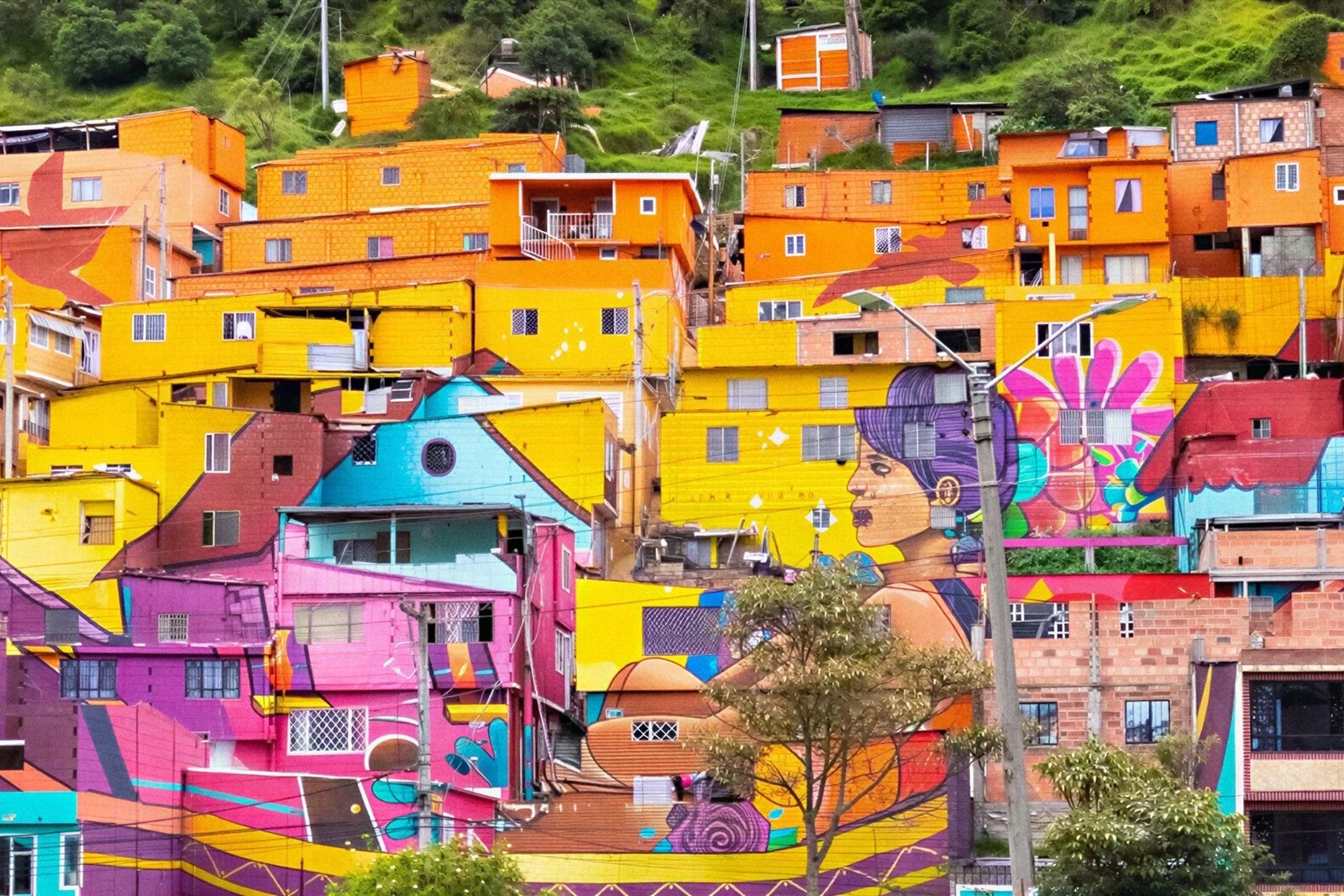 Vibrant hillside homes in Bogota, featuring large-scale murals. Hotels in Bogota | Tequendama Hotels | Official Web