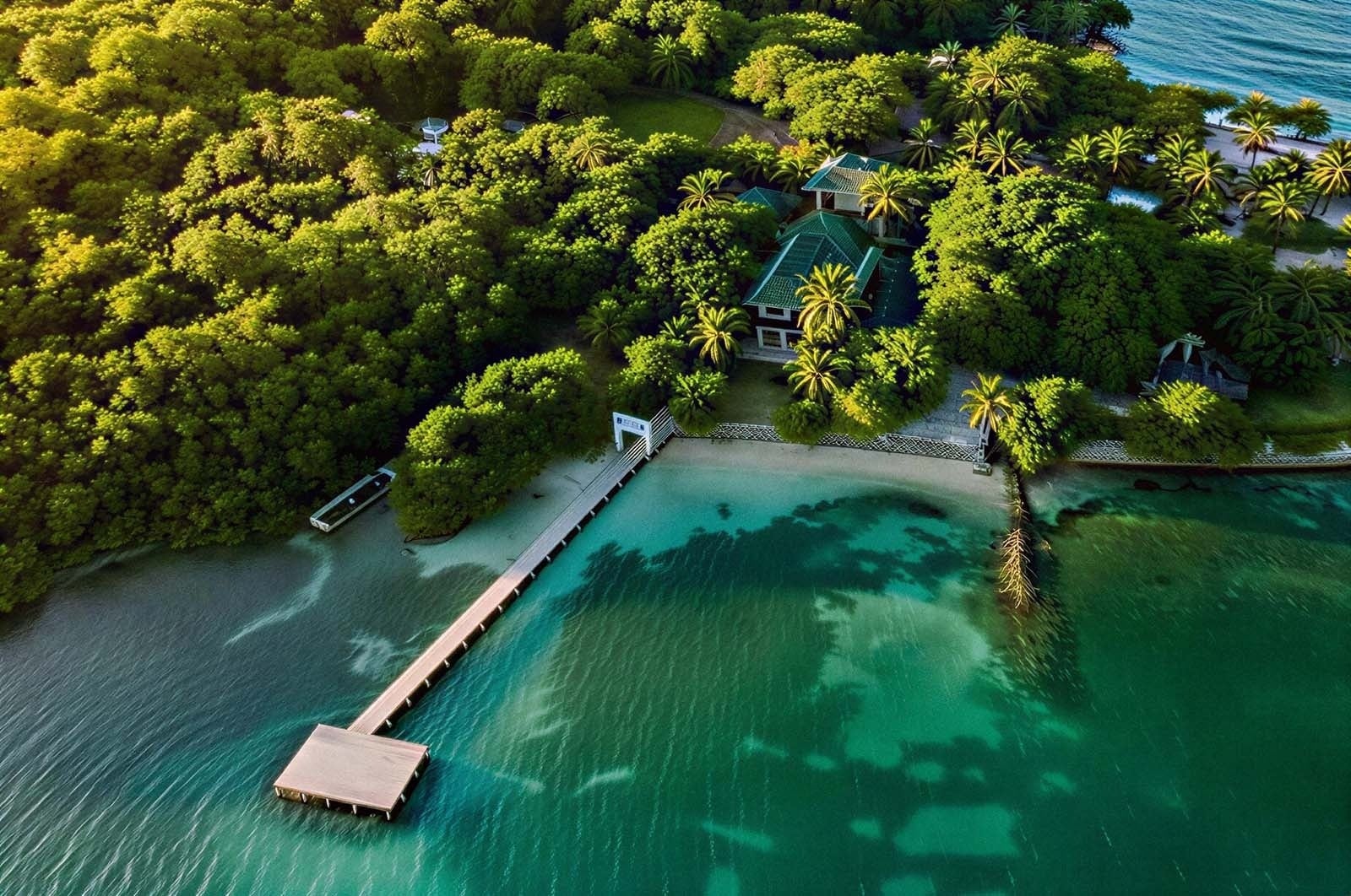 Hotel Rosario de Mar: Overwater dock and bungalows on a tropical island. Islas del Rosario hotel.