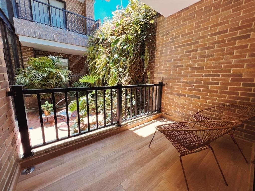 Balcón acogedor con sillas al aire libre, ideal para relajarse en Tequendama: Corporativa.