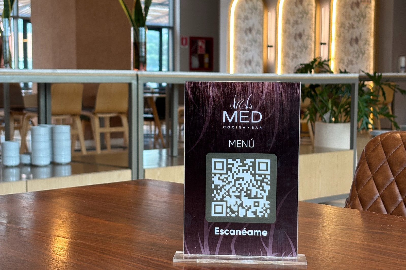 Tequendama: Corporativa QR menu sign on a table in a modern restaurant setting.