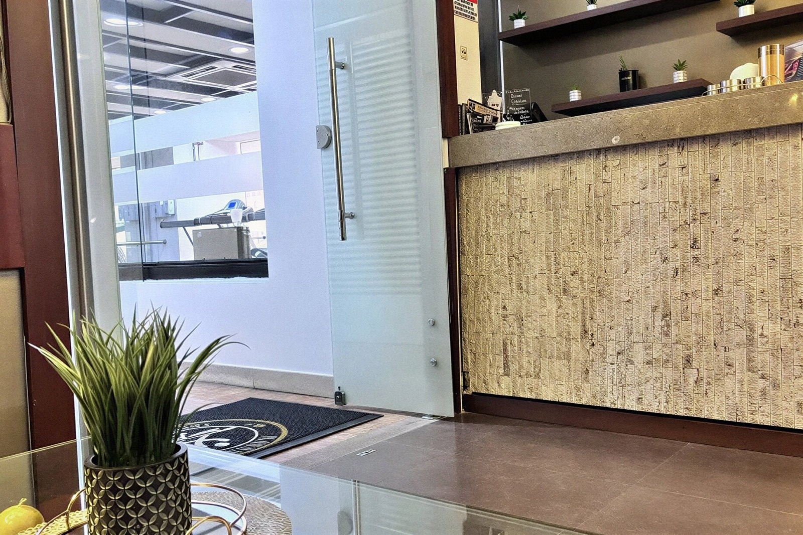 Recepción Tequendama: Corporativa con detalles dorados y planta ornamental.
