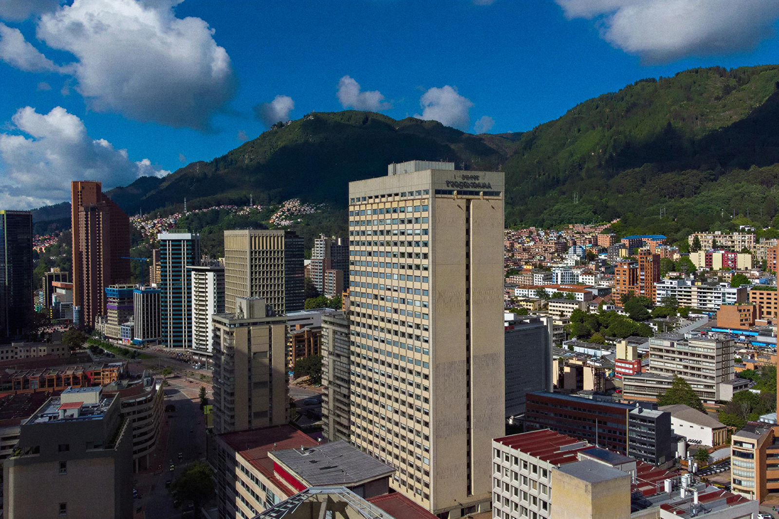 Tequendama Suites Bogotá: modern high-rise hotel in a vibrant city center, with mountains behind.