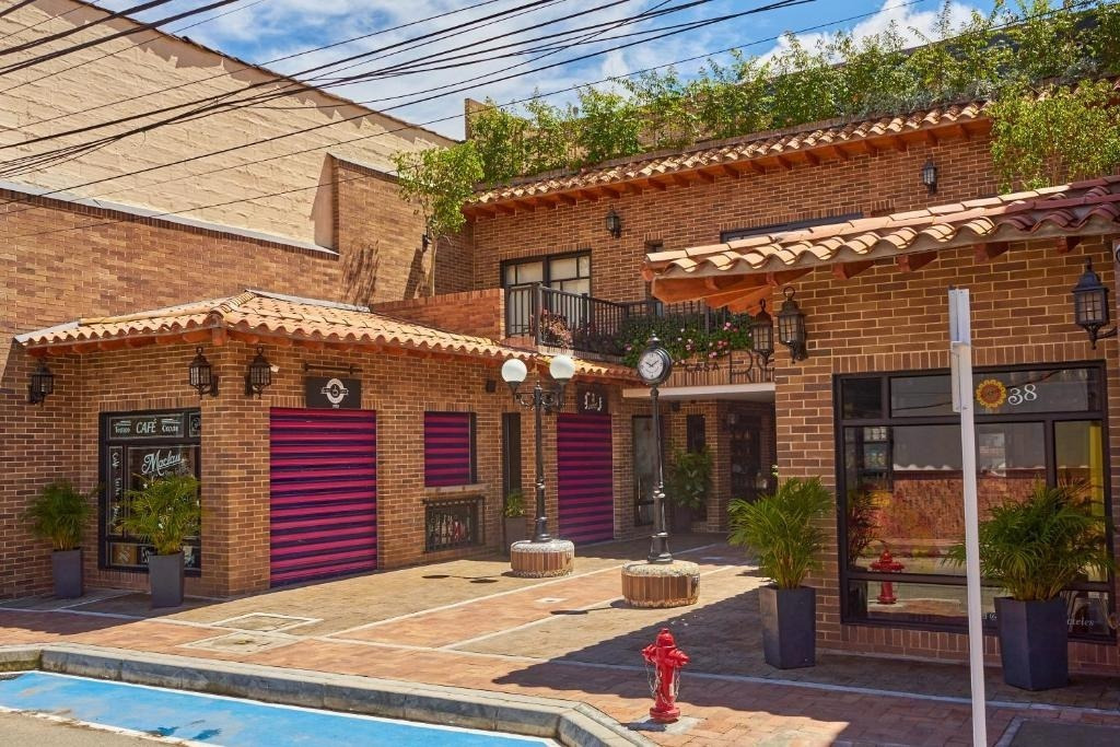 Casa Rosé Hotel: Charming brick facade with tiled roof & outdoor seating in El Carmen de Viboral.